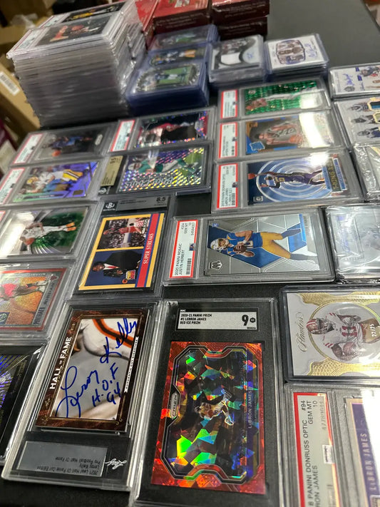 Collection of trading cards and autographed memorabilia in protective cases for card community spotlight.